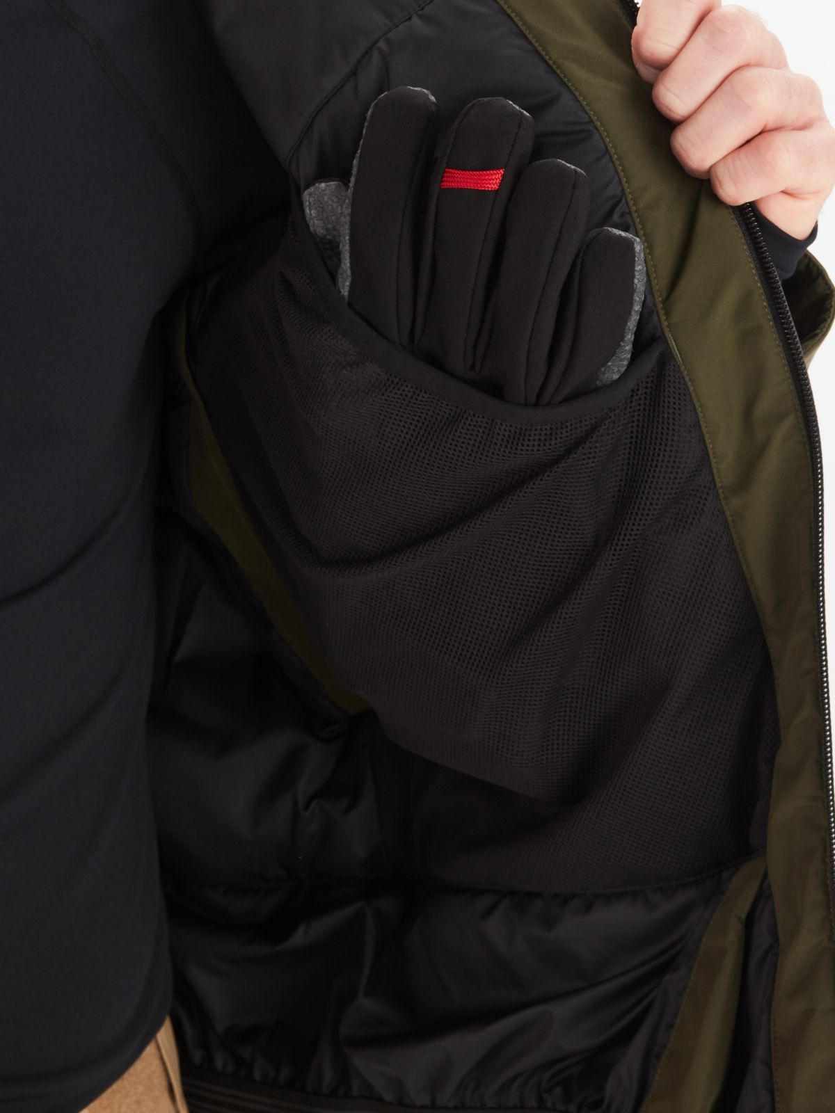 close up of a glove inside the pocket of a mens parka jacket