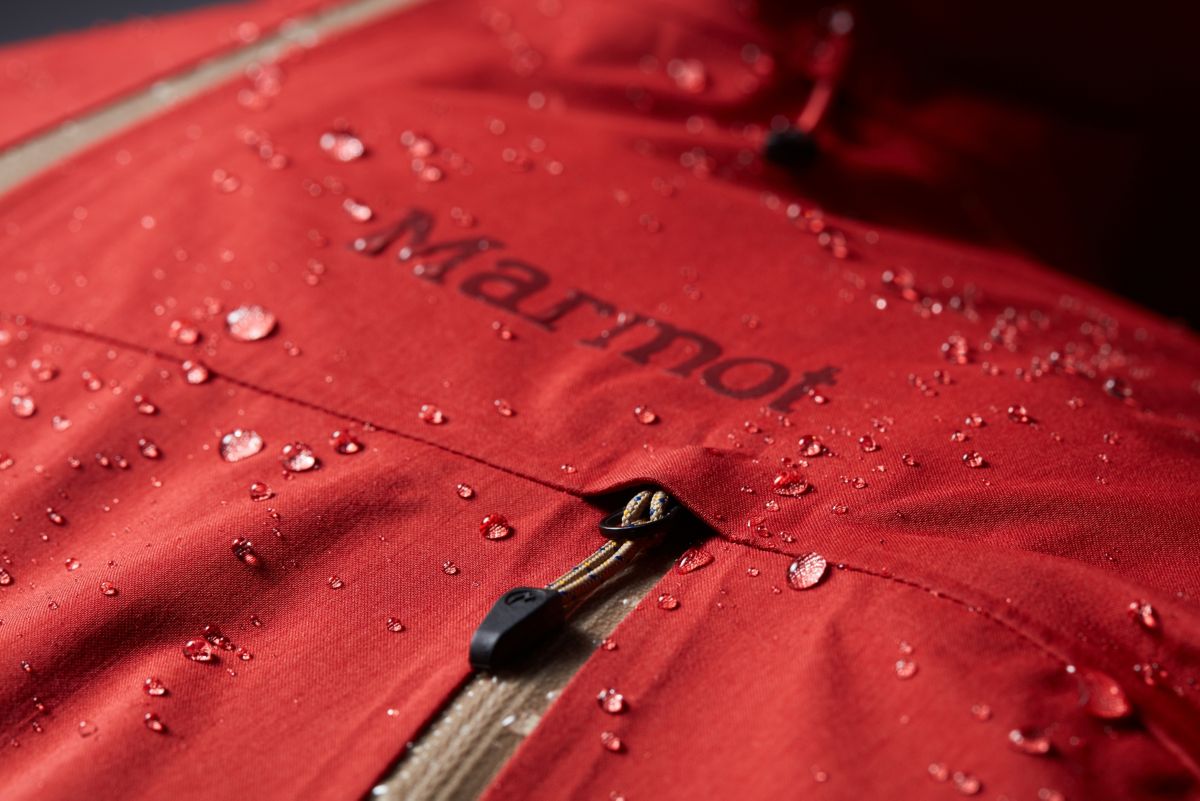 Model displaying drawcord hem on Marmot men's jacket in red
