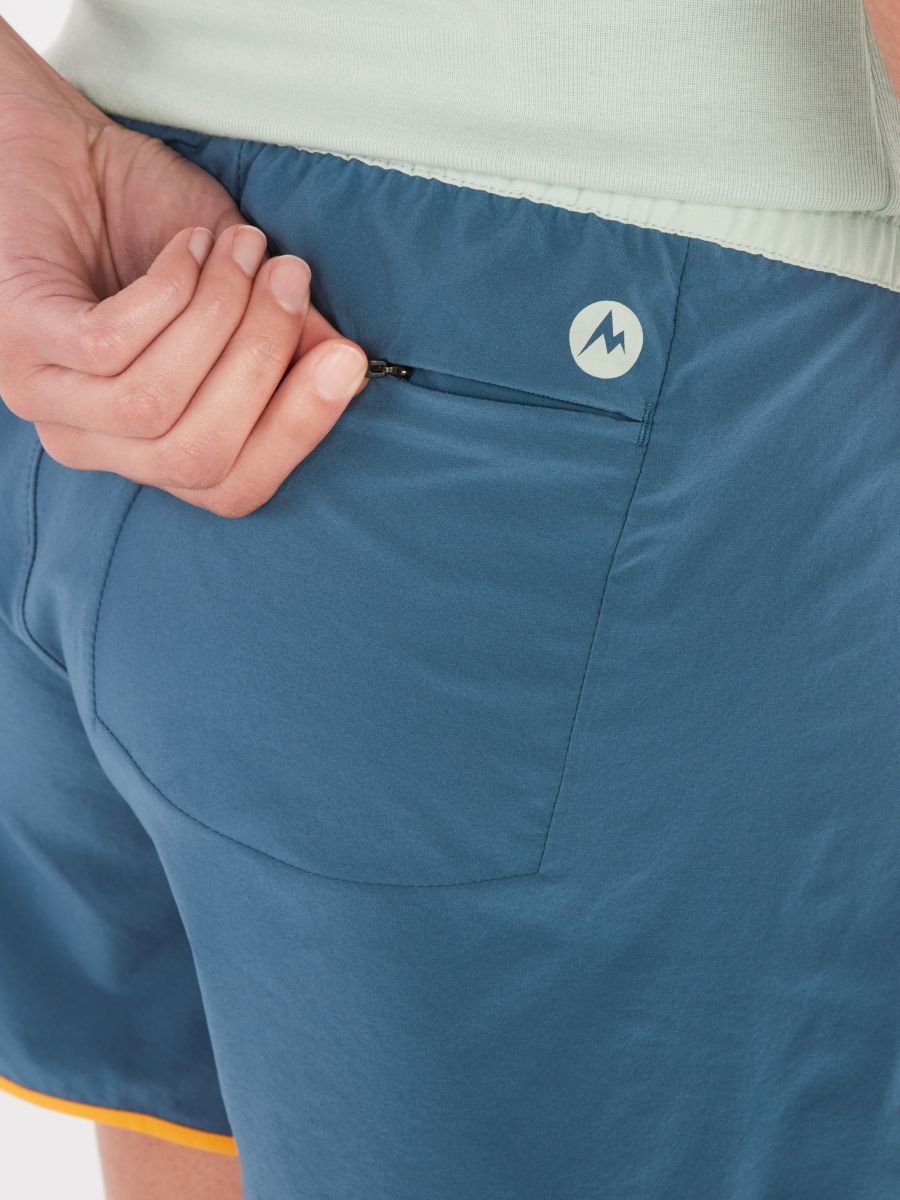 Person zipping back pocket on shorts