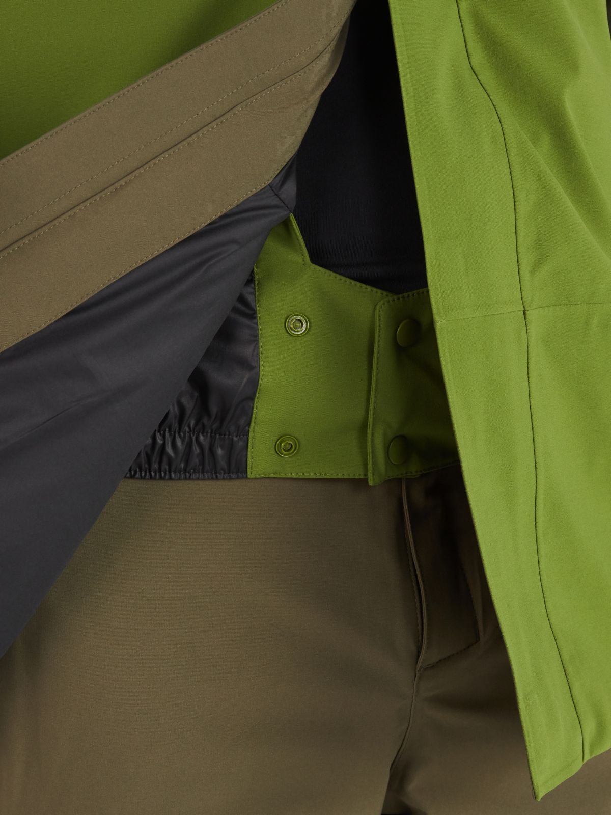 Model displaying inner lining of Marmot men's jacket in lime green