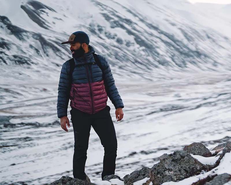 man in outdoor clothing enjoying a hike through the mountains