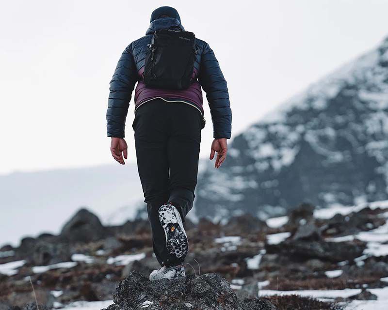 man in outdoor clothing enjoying a hike through the mountains