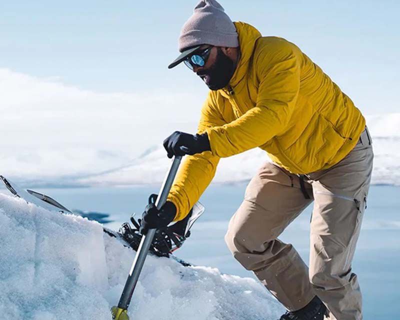man in outdoor gear preparing to snowboard