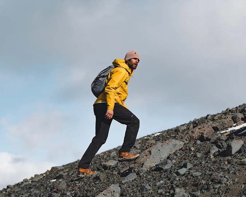 man in outdoor clothing enjoying a hike through the mountains